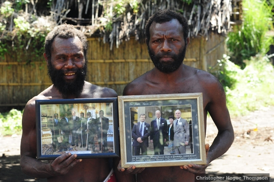 Yaohnanen tribesmen show framed pictures of their 2007 visit with Prince Philip