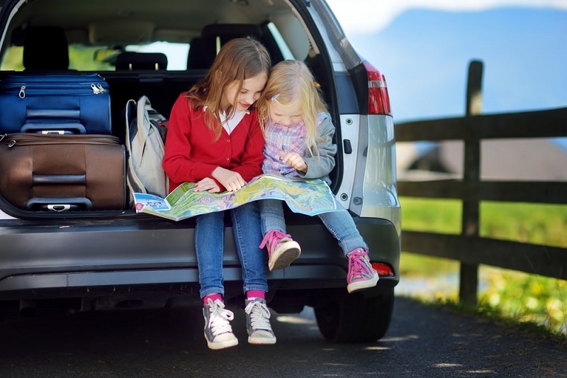 Kids sit in a car boot